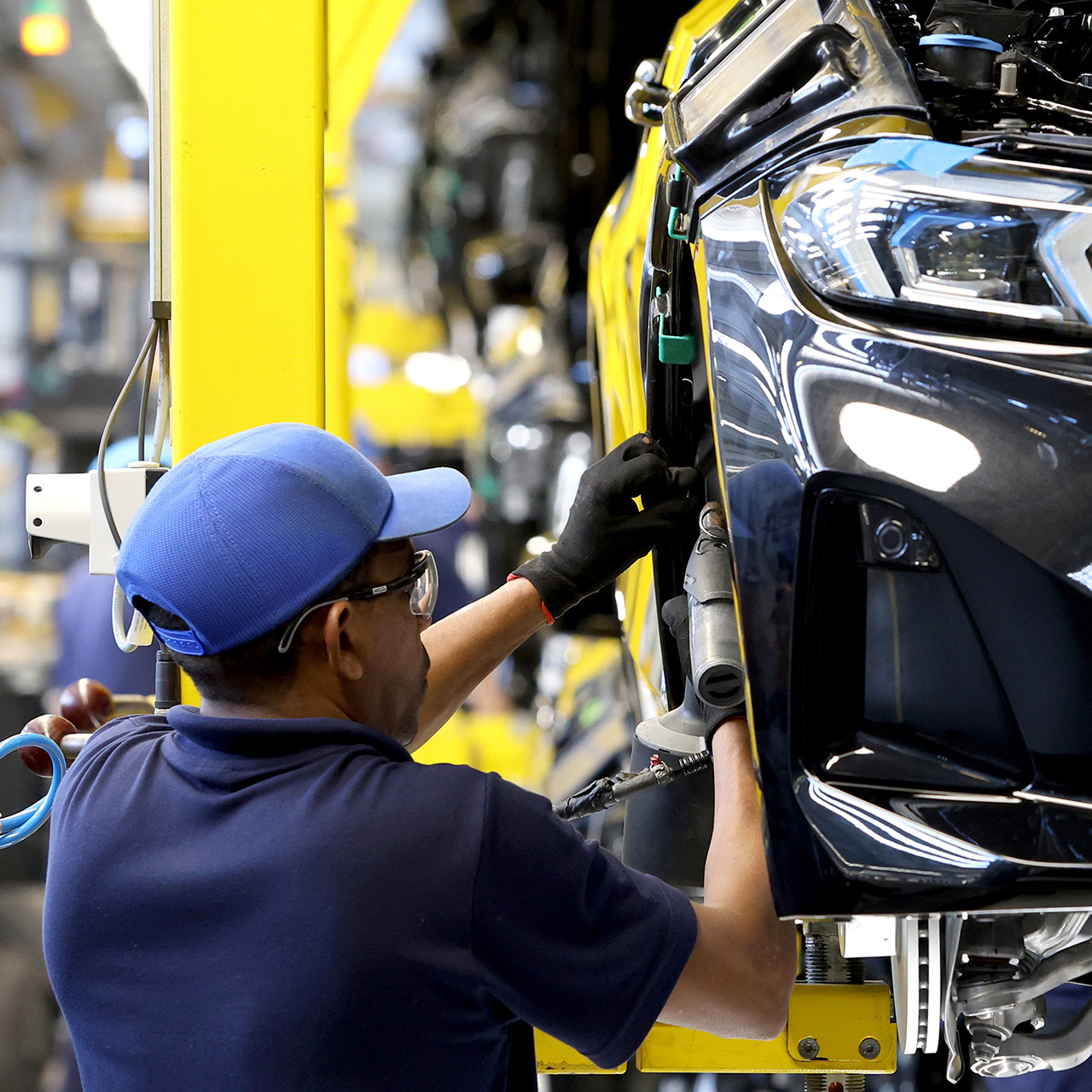 Factory worker assembles a BMW vehicle