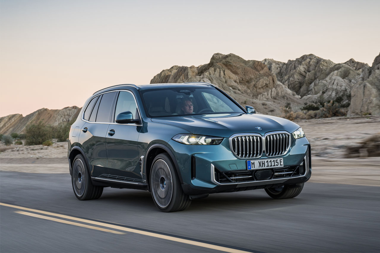 BMW X5 dirigindo em uma estrada rural