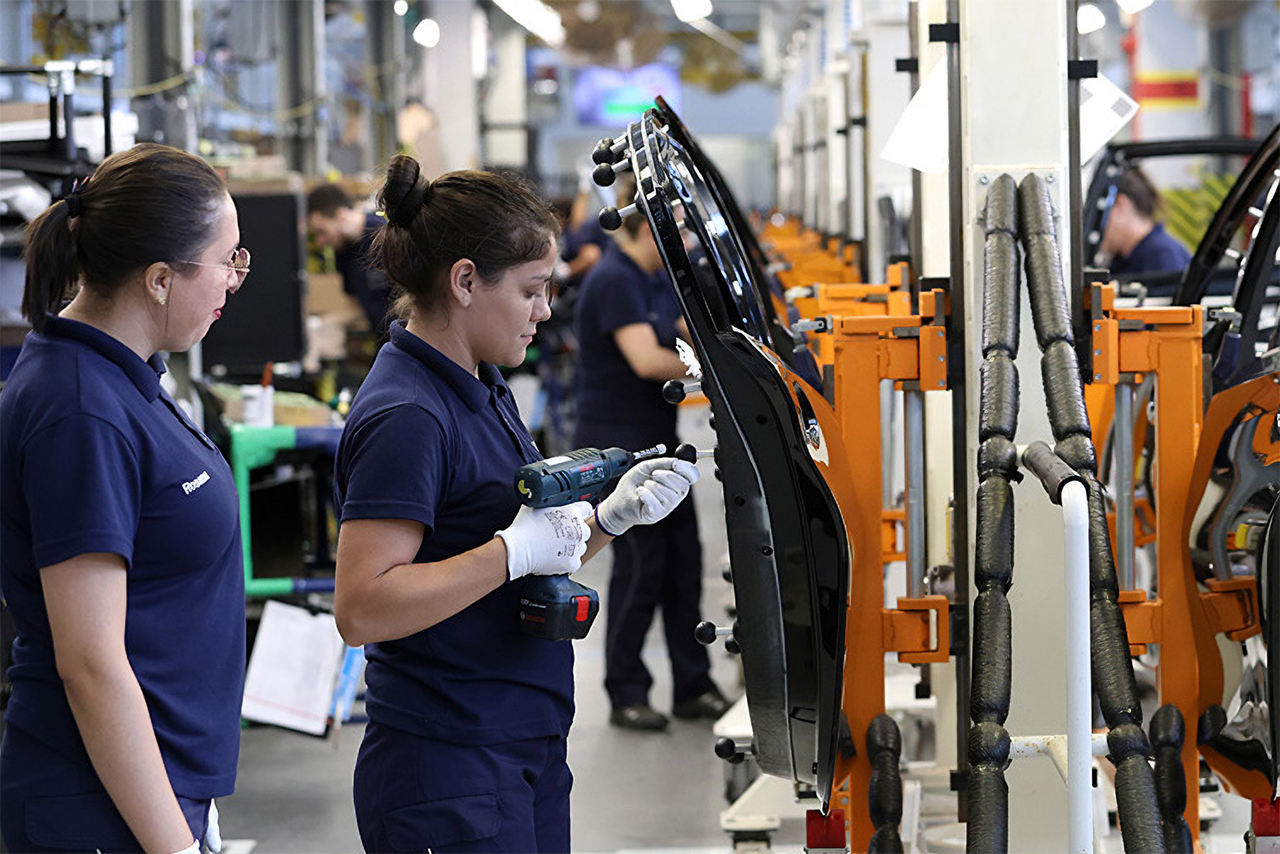 Trabalhadores de fábrica montam peças em um veículo BMW