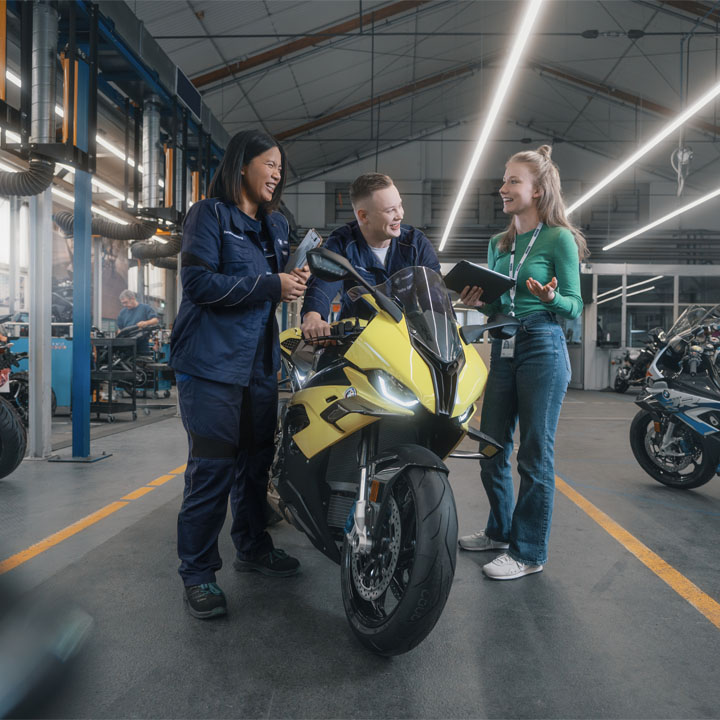 Auszubildende neben einem Motorrad im BMW Group Werk Berlin.