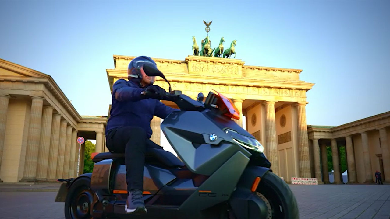 Ein Mann fährt mit einem Motorrad vor Brandenburger Tor.