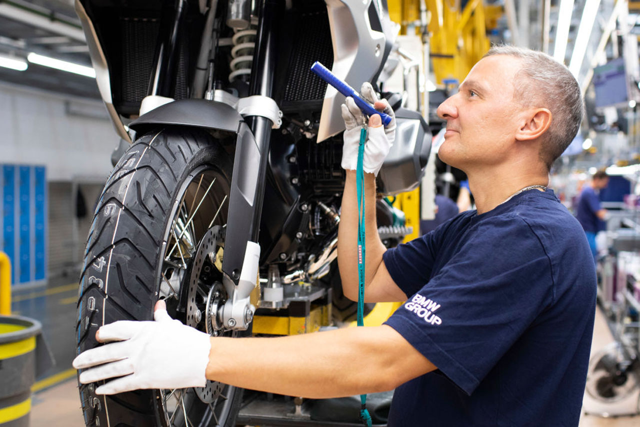 Ein Mitarbeiter überprüft die Qualität eines Neu angefertigten Motorrads.