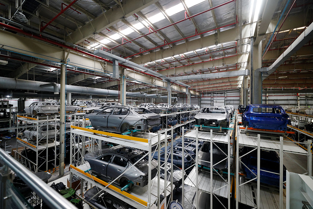  Interior view of the BMW Group Plant Chennai storage facility with various BMW Group vehicles organized on racks.