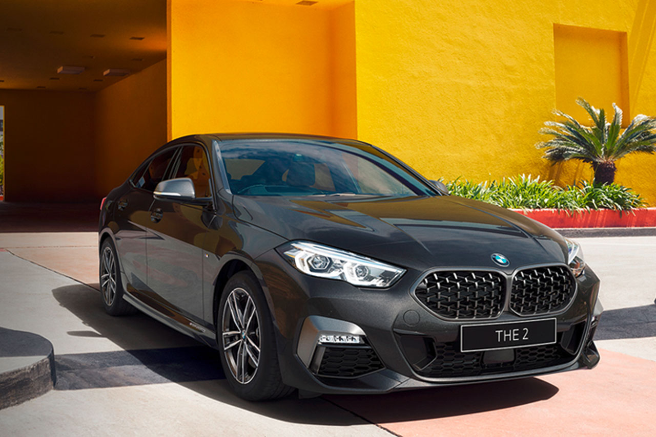 Grey BMW 2 Series Gran Coupé standing infront of a bright yellow wall.