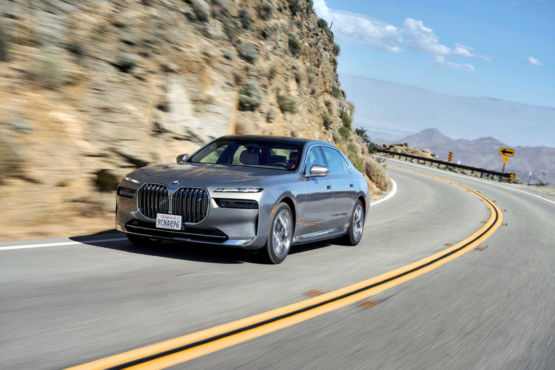  Grey BMW 7 series driving on a scenic road through the nature.