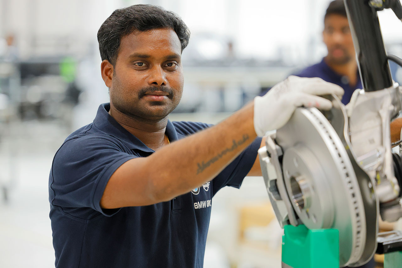 A BMW Group employee is working on the brakes of a new BMW vehicle.