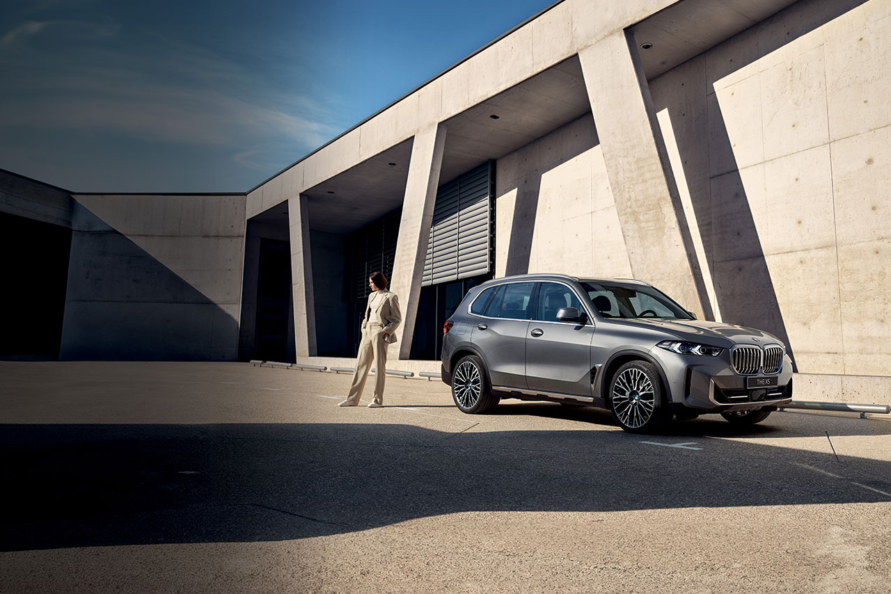  Grey BMW X5 parked infront of a modern building.