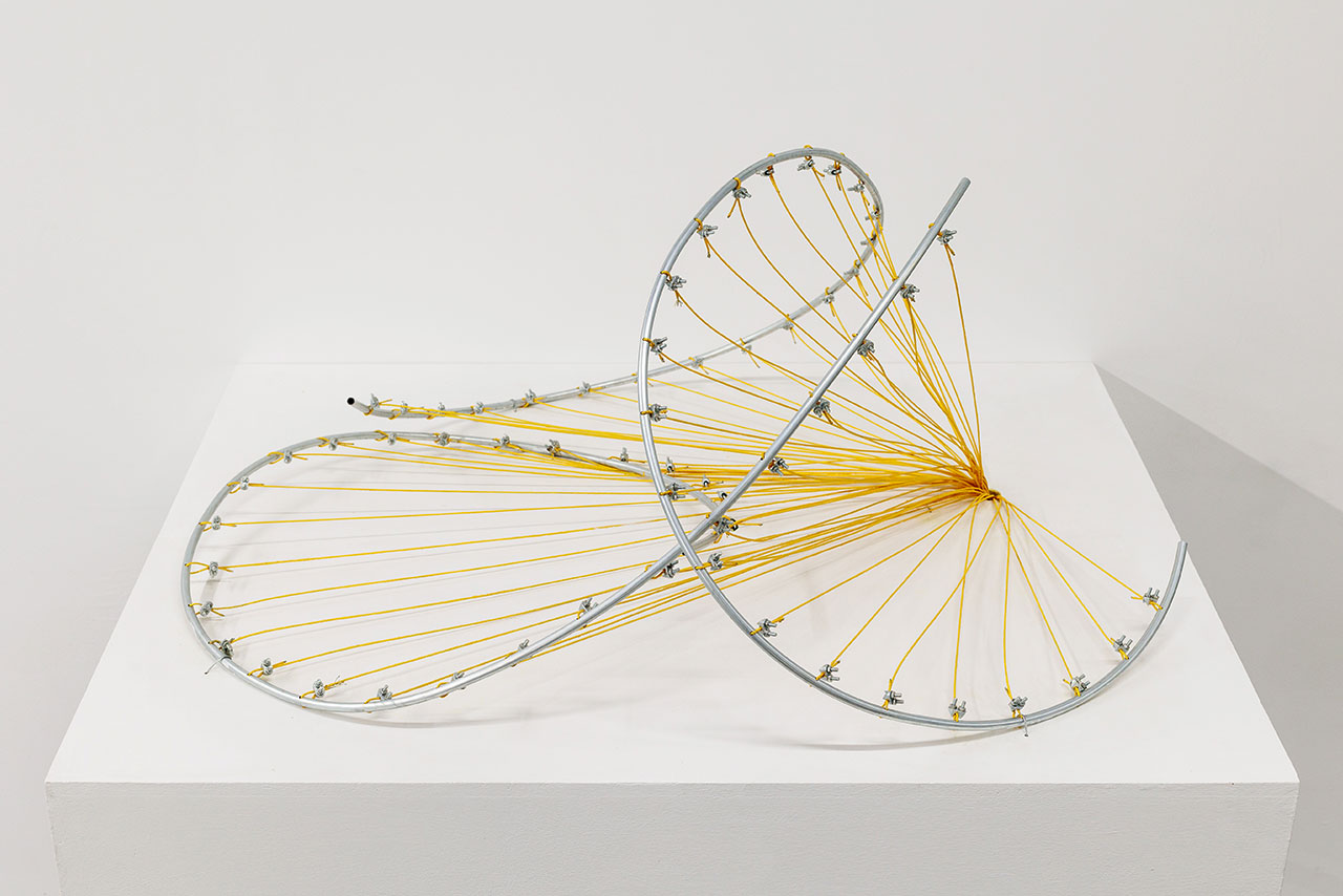 Hyperbolic parboloid composed of struts and threads on a white base