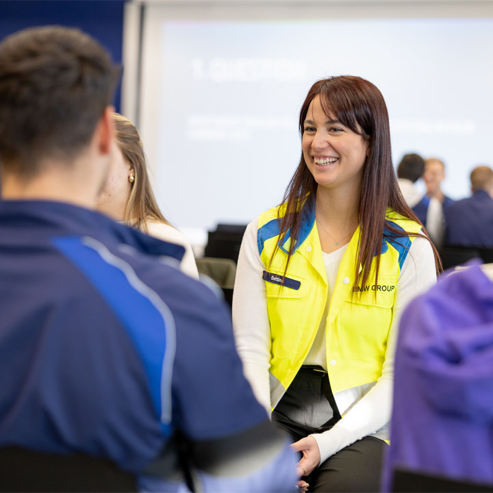  A woman and a man sitting together, the woman in a chair, sharing a moment in a relaxed environment.