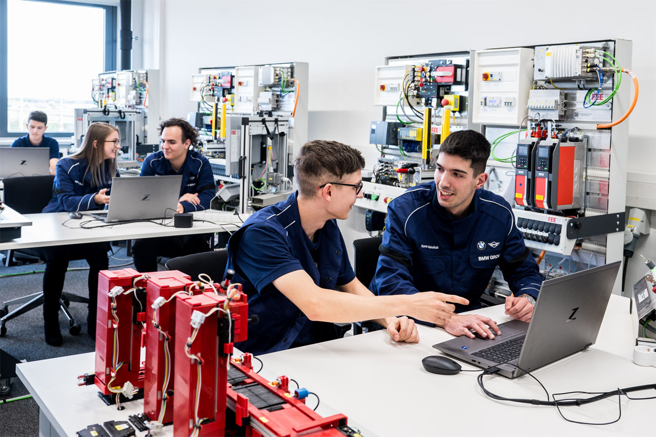 Diákok egy laptopon dolgoznak az osztályteremben, együttműködve és tanulva egymástól.