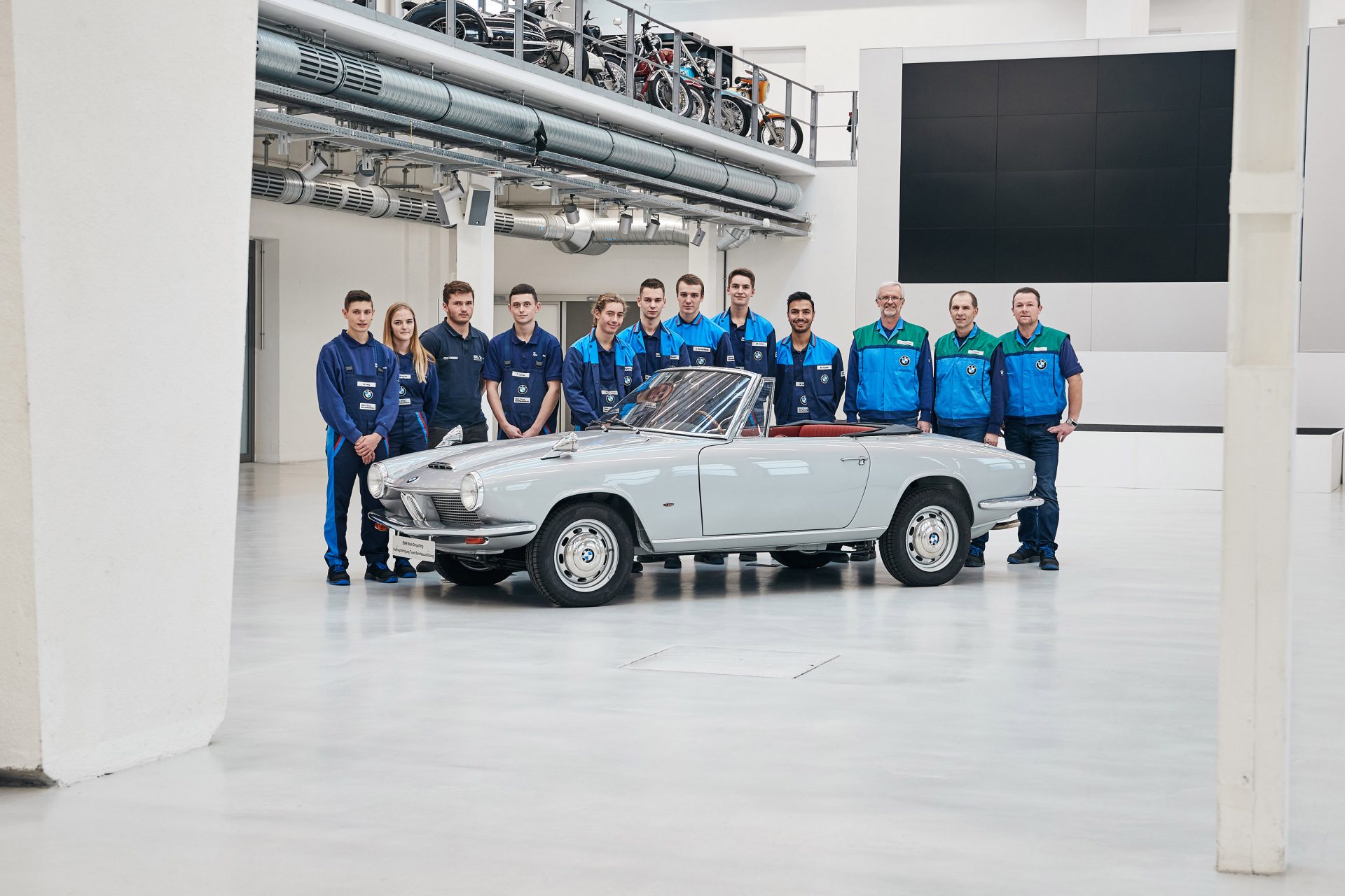 Dingolfinger Ausbildungsmeister und Auszubildende mit dem BMW 1600 GT Cabriolet bei der Fahrzeugübergabe in der BMW Group Classic 