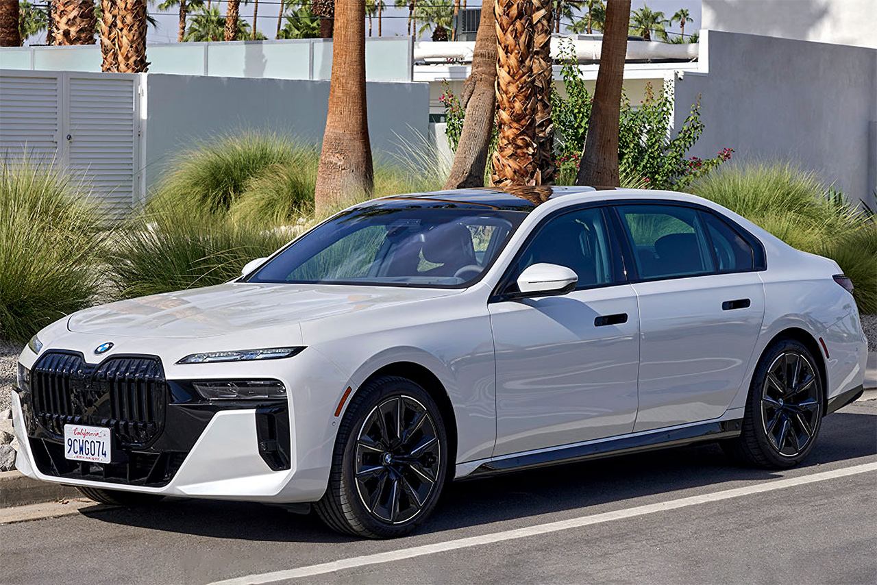 Weißer BMW 760i XDR auf einer Straße mit Palmen im Hintergrund.