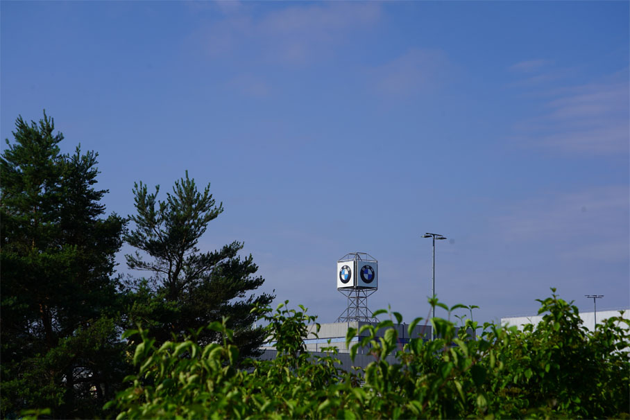 A BMW clock tower under a bright blue sky.