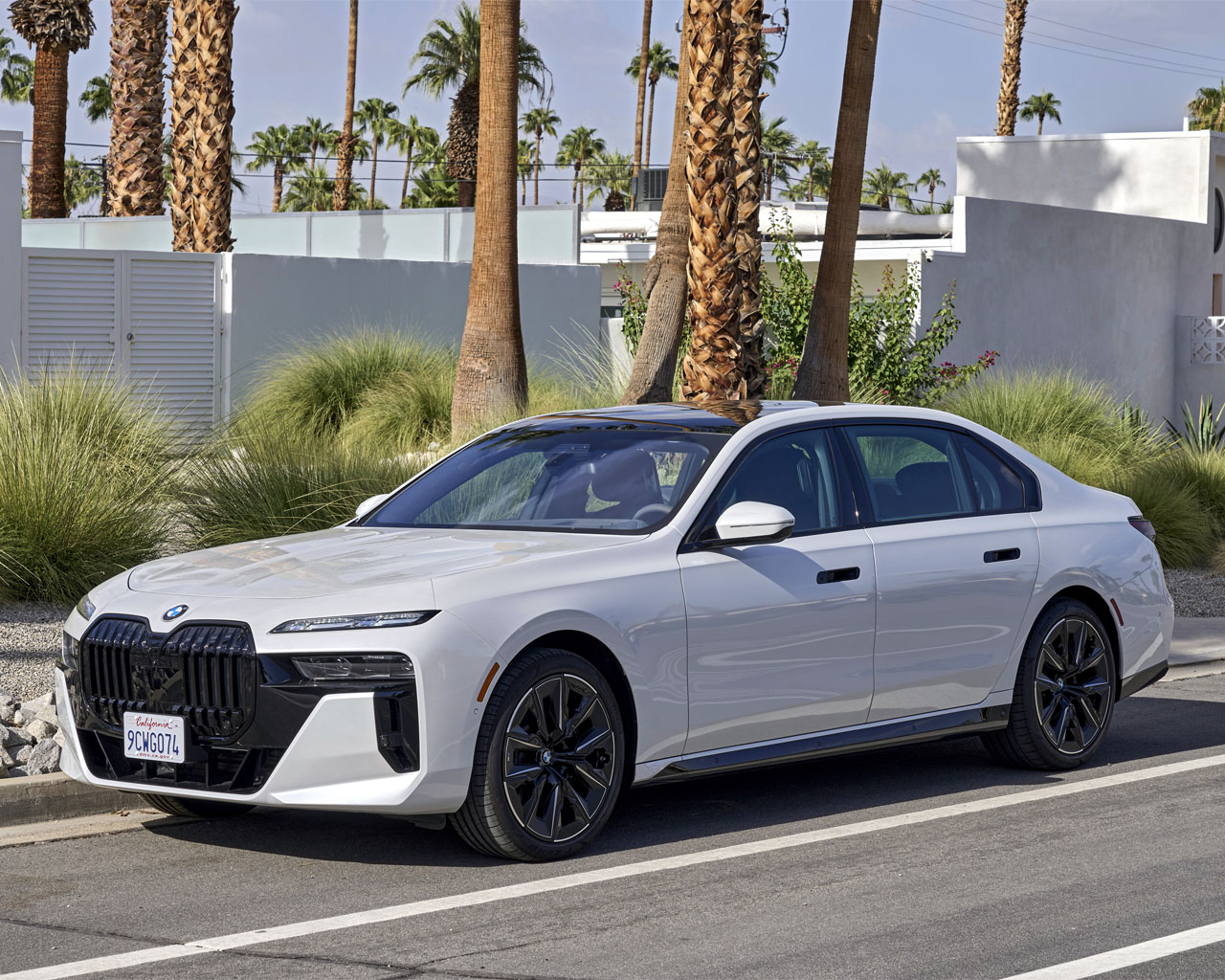 White BMW 760i XDR on a road with palm trees in the background.