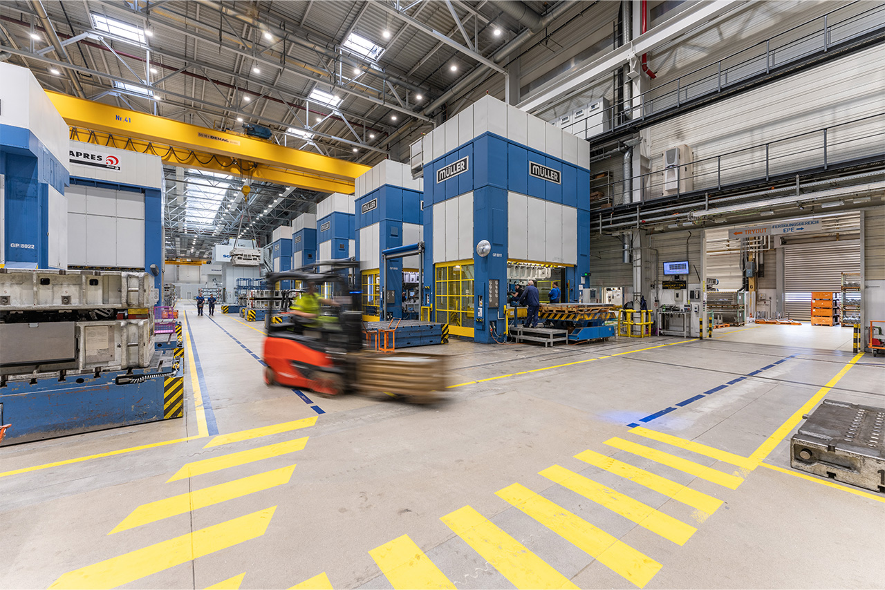 Ein Gabelstapler fährt durch eine große Lagerhalle bei der BMW Group.