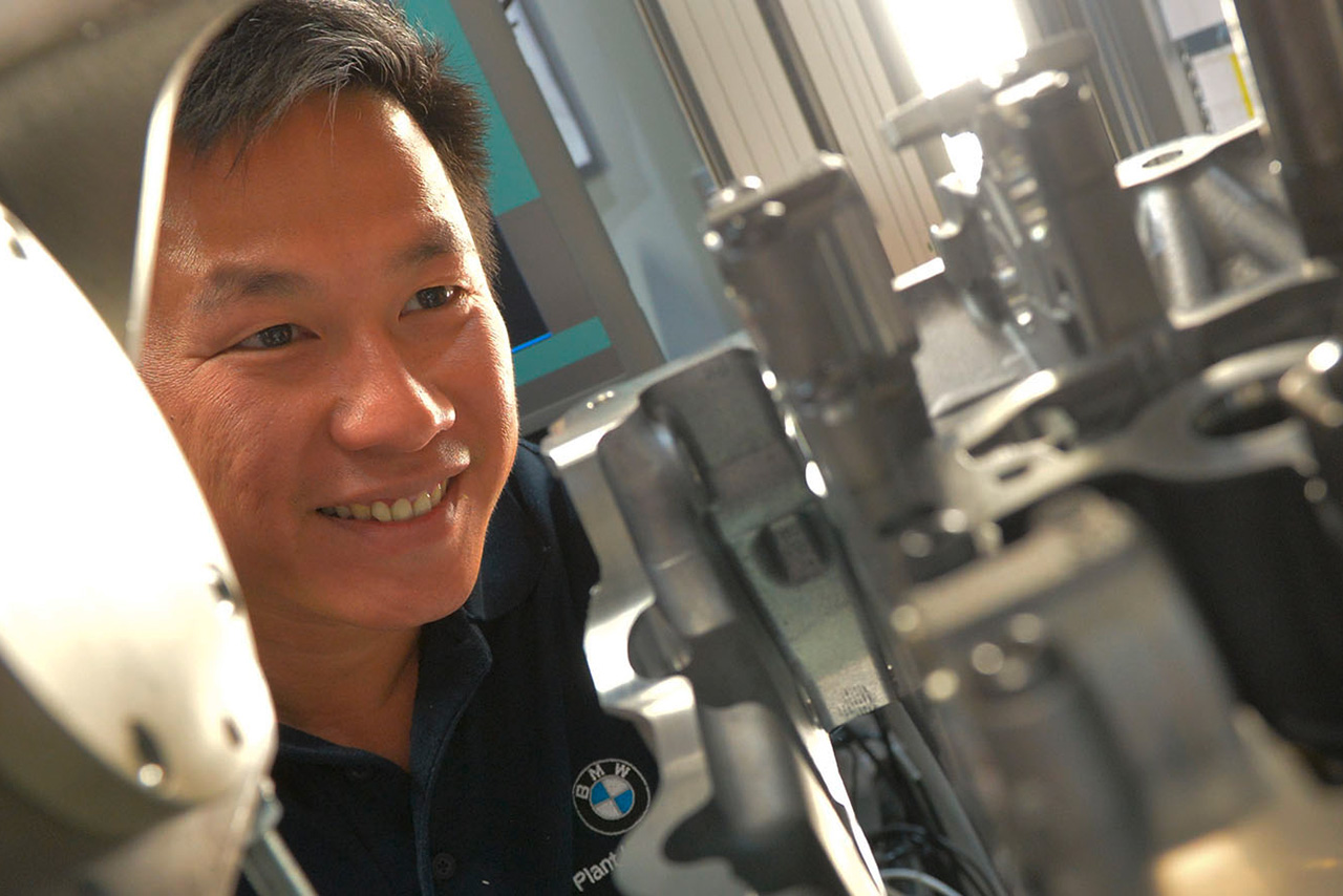 An employee is working on the motor of a new BMW vehicle.