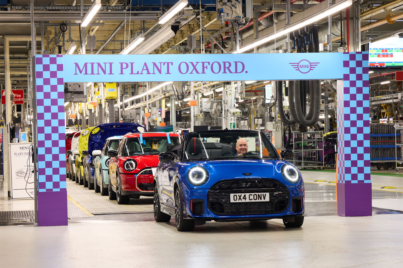 Production line at MINI Plant Oxford with various colourful cars rolling through the finish line.