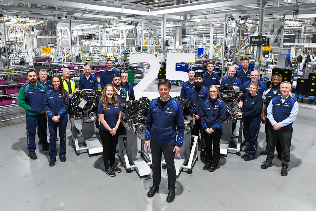 Numerous BMW employees pose for a photo among current engines at the BMW Group plant Hams Hall to mark the 25th anniversary.