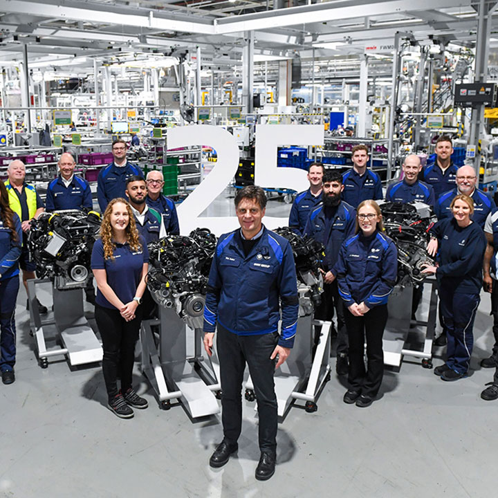 Numerous BMW employees pose for a photo among current engines at the BMW Group plant Hams Hall to mark the 25th anniversary.