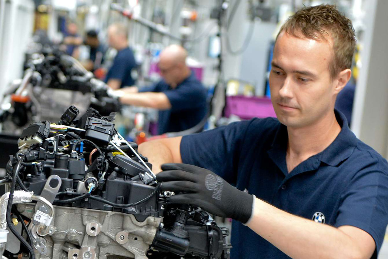 An employee in the BMW Group plant Hams Hall is working on the motor of a BMW vehicle.