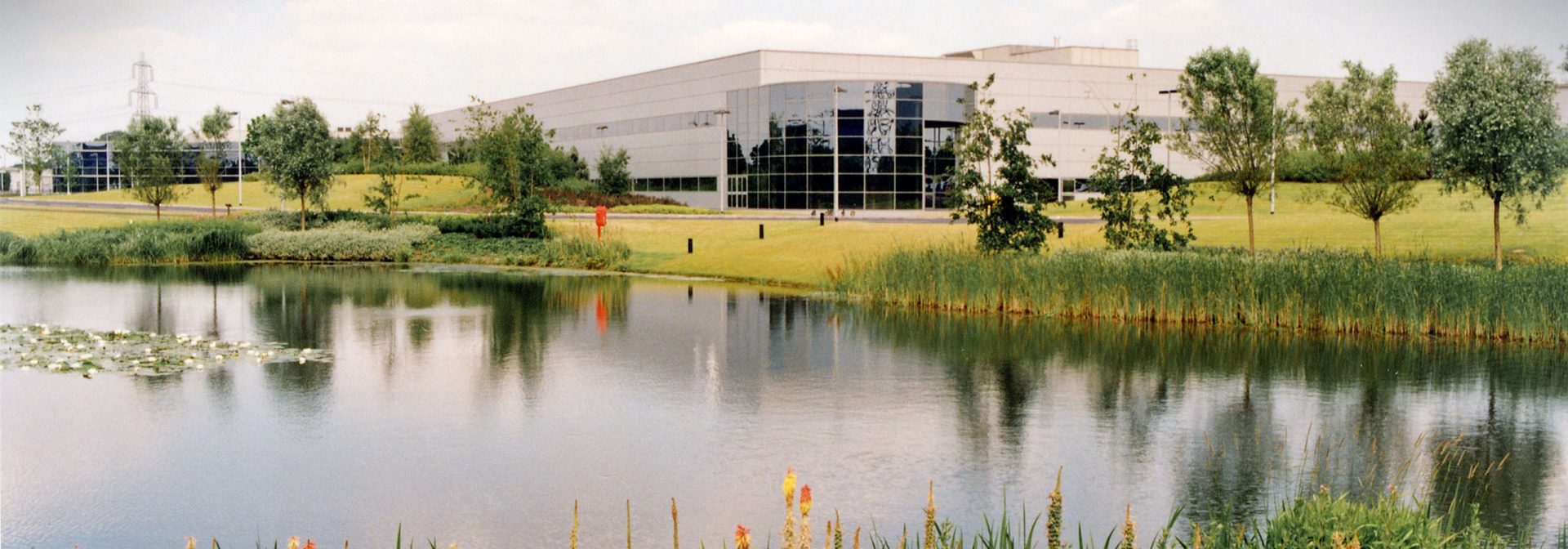 A prominent building is situated in front of a tranquil pond, enhancing the landscape.