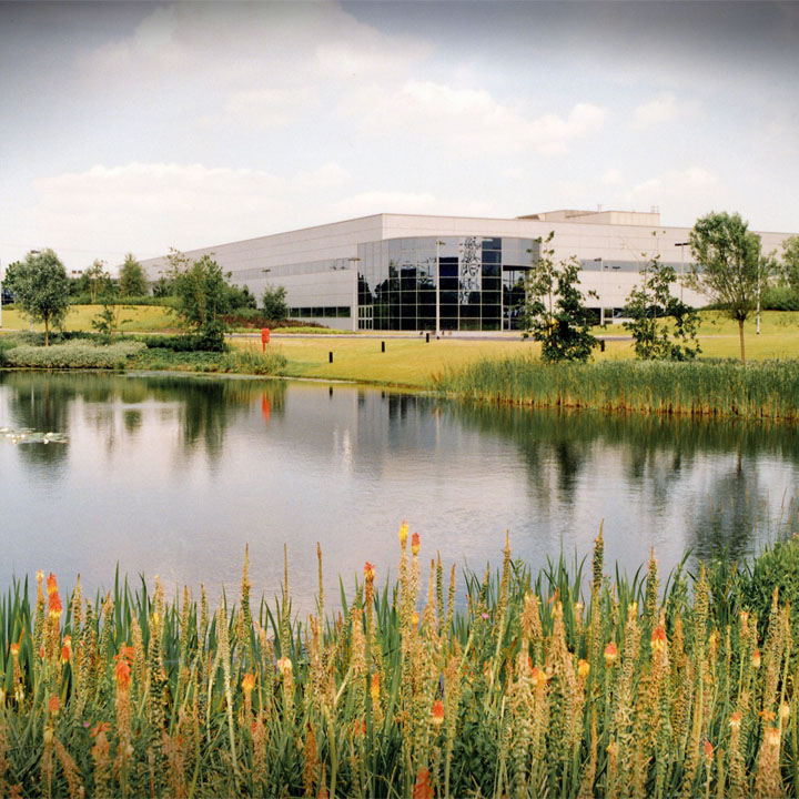 A prominent building is situated in front of a tranquil pond, enhancing the landscape.