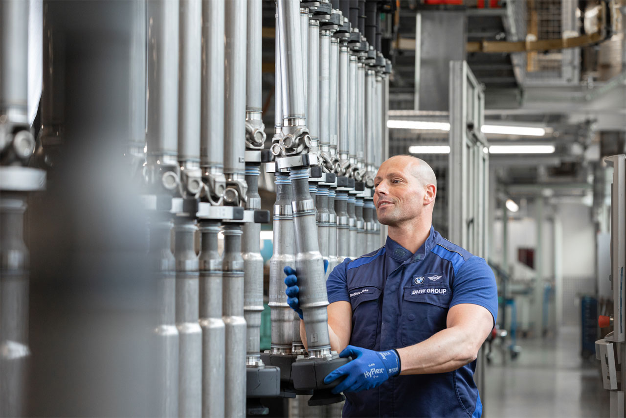 Ein Mitarbeiter der BMW Group prüft Gelenkwellen, bevor sie verbaut werden.