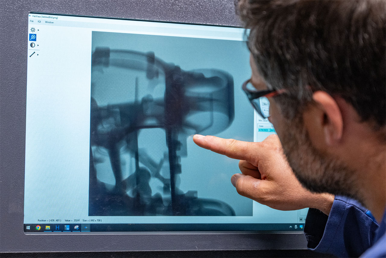 Ein Mann weist auf ein Bild, das auf einem Computerbildschirm angezeigt wird.