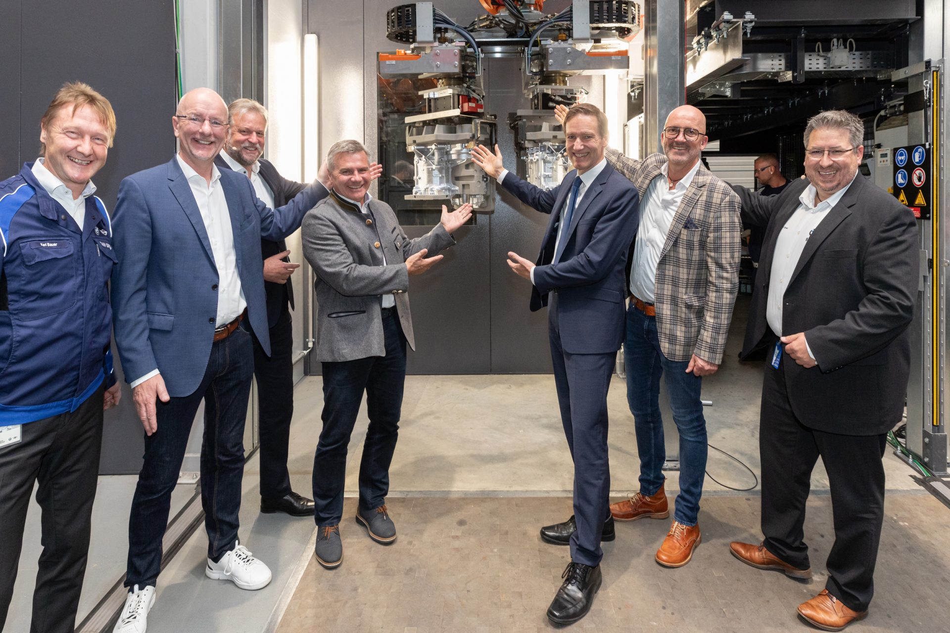 Personen zeigen auf die Produktion der Gehäuse der Motor-Getriebe-Varianten für vollelektrische Fahrzeuge