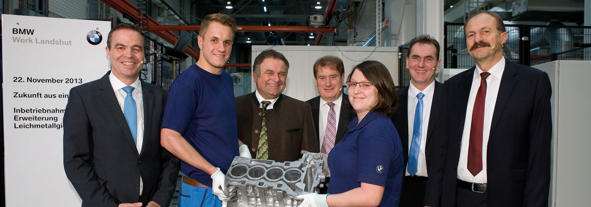 People show the camera a manufactured part of an engine.