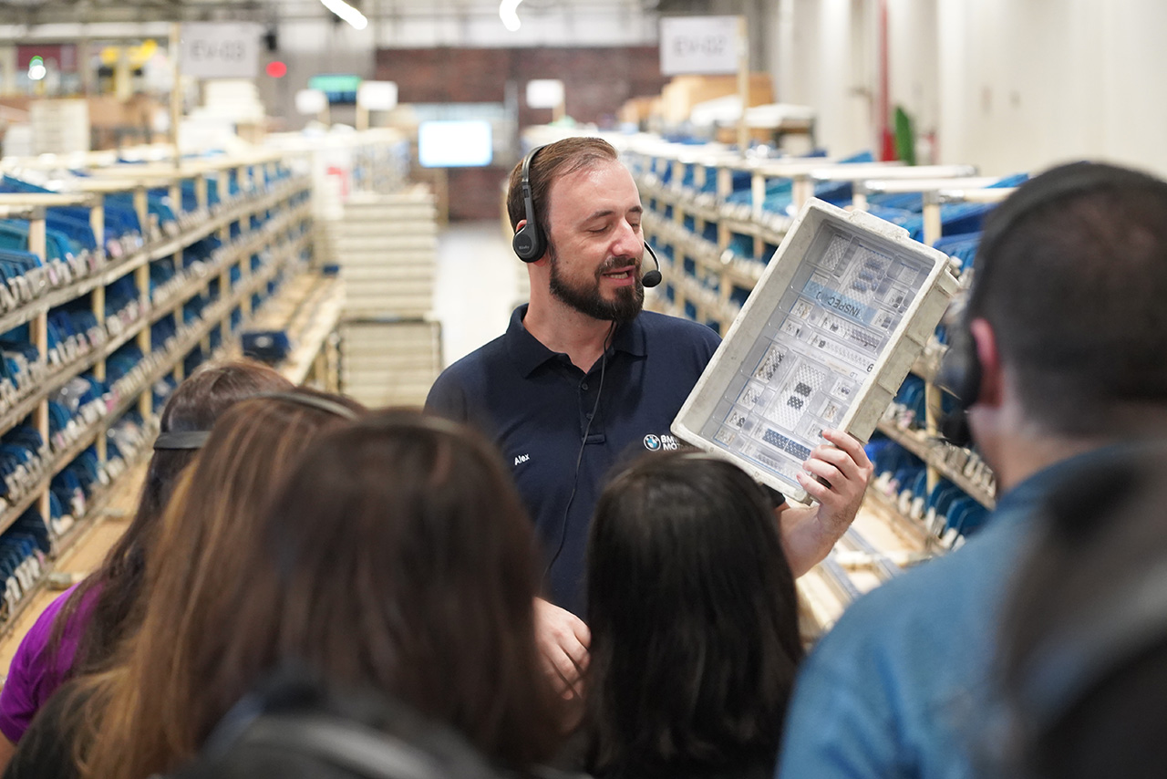 A tour guide form the Manaus Plant is explaining something to visitors.