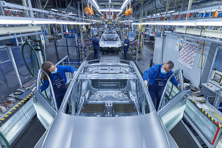 Zwei Personen im Karosseriebau bei der BMW Group, die an einer Karosserie Arbeiten