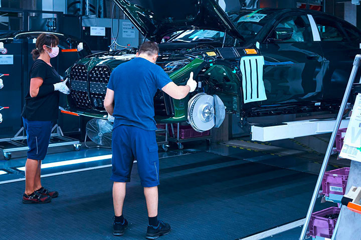 Mitarbeiter bei der Montage von Teilen an einem Fahrzeug.