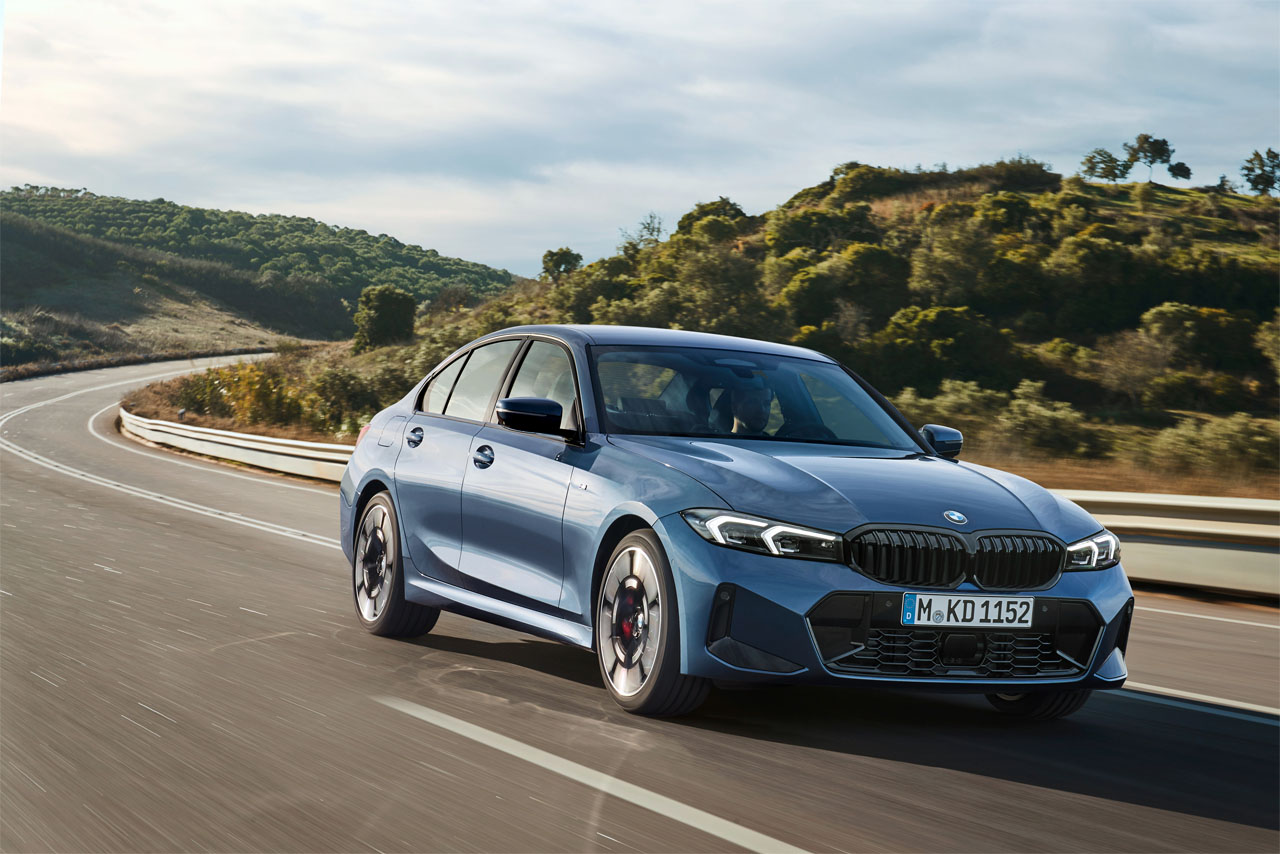 Blaue BMW 3er Limousine fährt in der Natur.