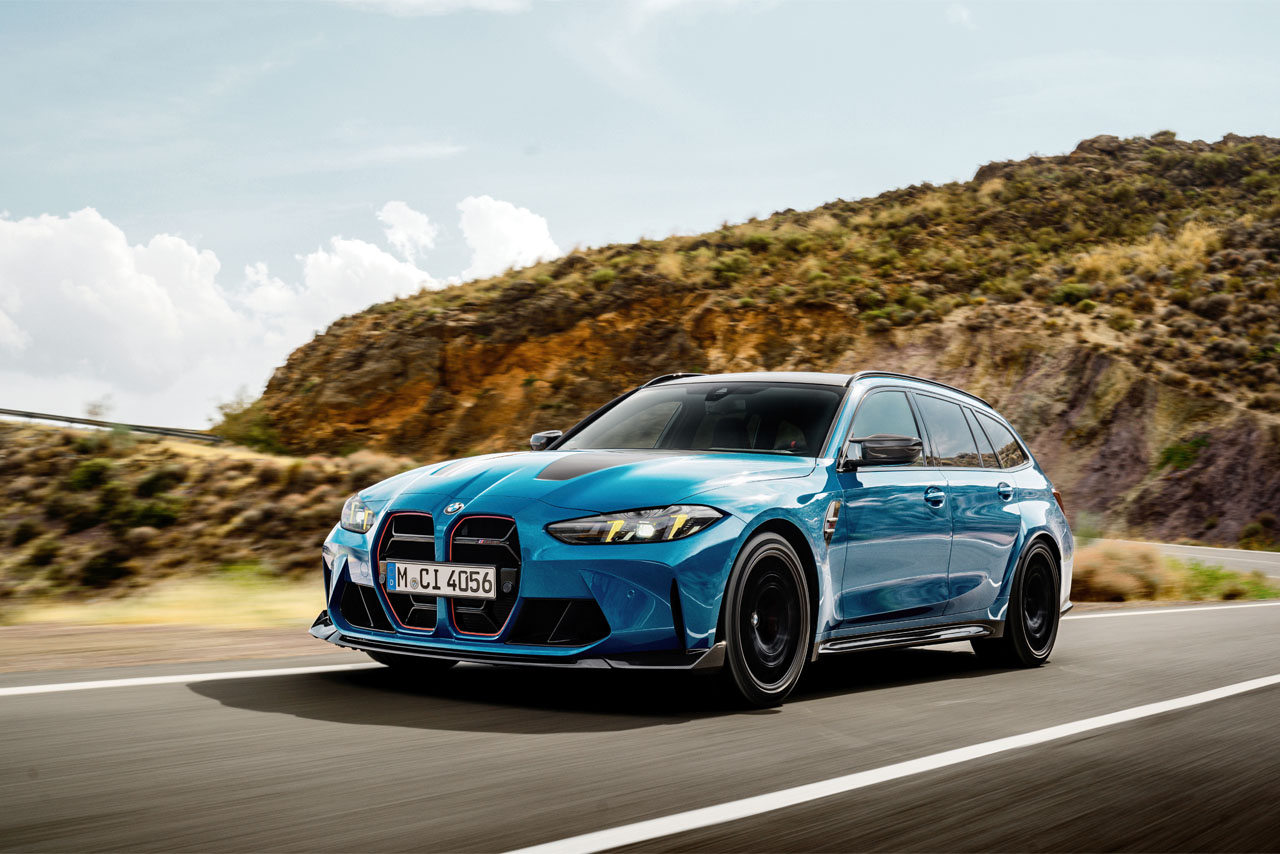 Blauer BMW M3 CS Touring fährt durch die Natur.