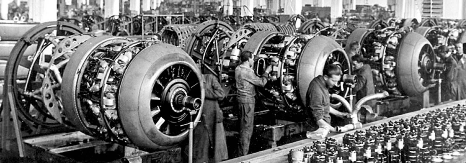 1940s aircraft engine factory showcasing assembly workers and engines.