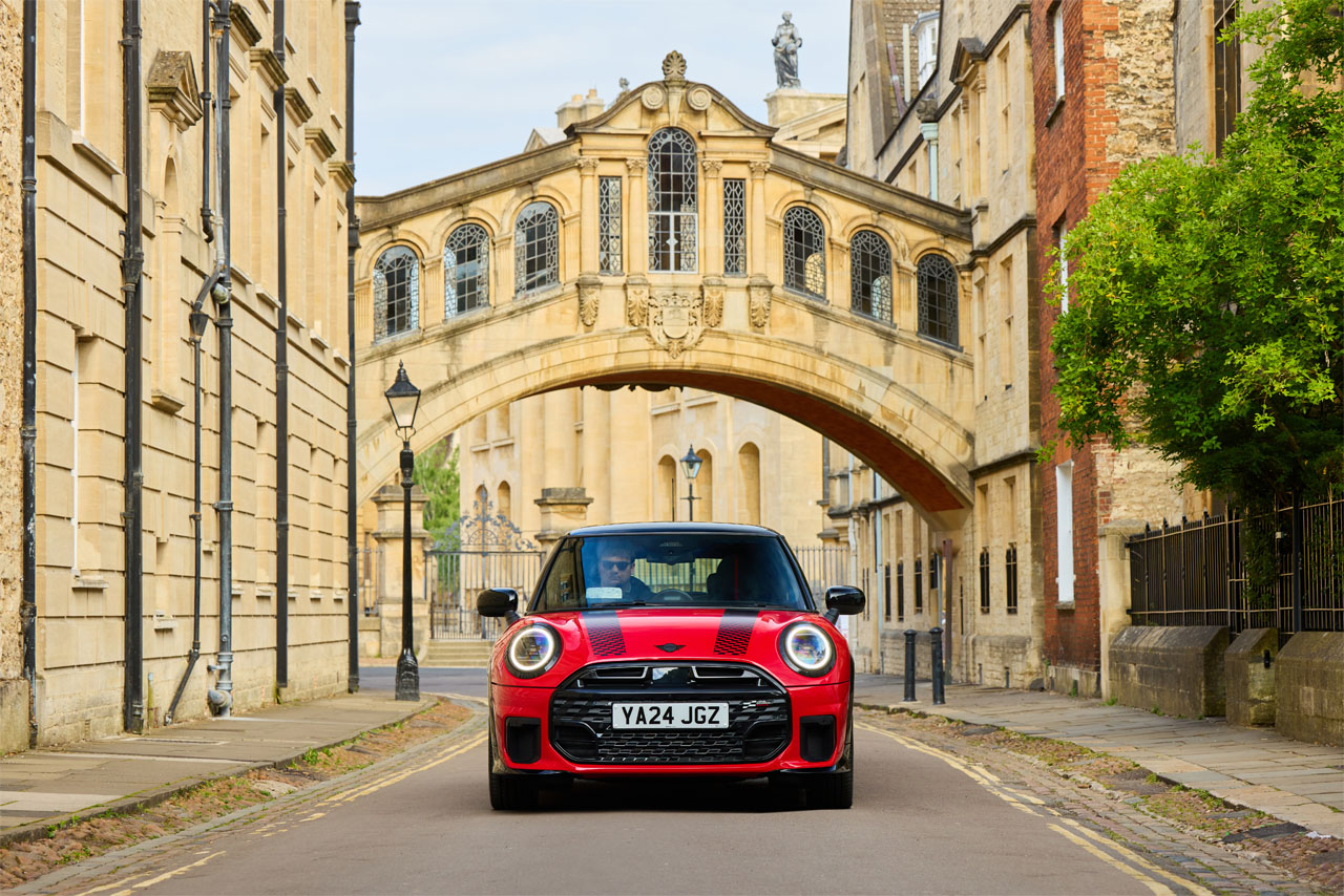 MINI Cooper S in a sporty design, red with black accents, parked on a street.