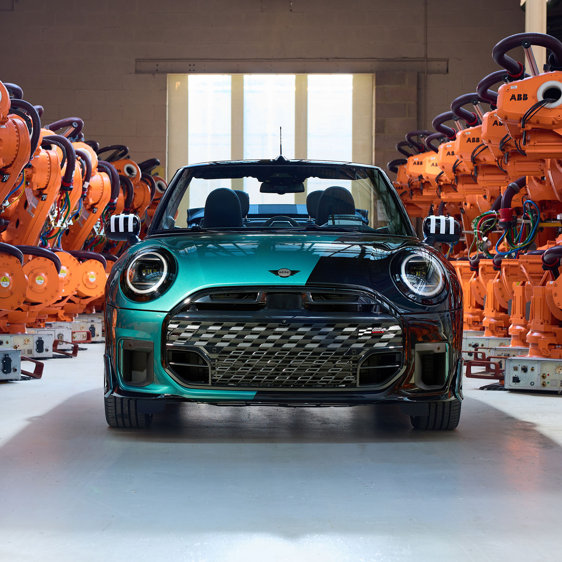 A huge team of BMW employees posing togther with the first ever MINI Cooper convertible off the Oxford plant. 