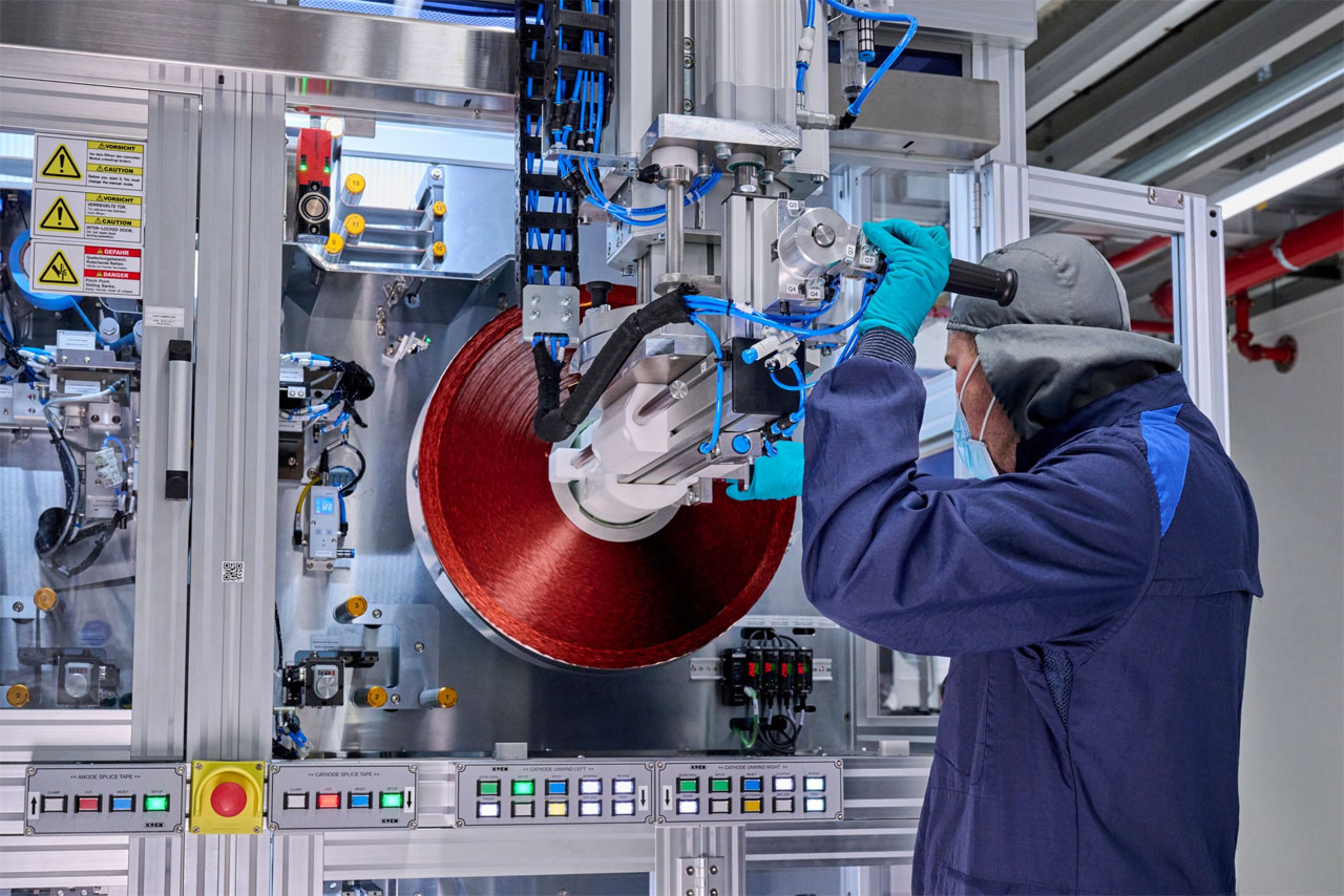 Ein Mann in blauer Jacke arbeitet an einer Maschine, um die Funktionen zu verbessern.