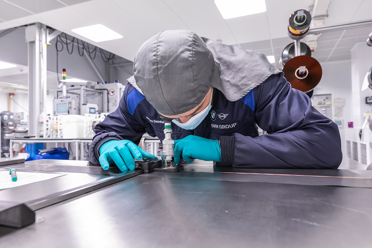 Laboratory employee of the Battery Cell Competence Center looks through a microscope.