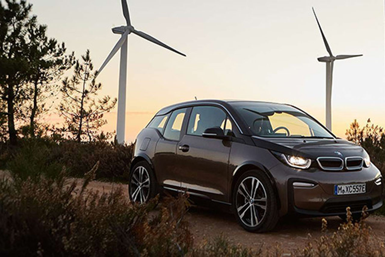 BMW i3 electric car parked in the nature, infront of wind edges to showcase modern design and eco-friendly features.