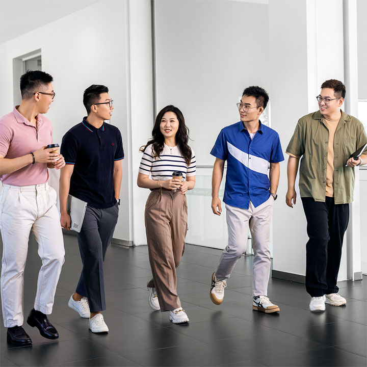 A group of recent graduates walking through a huge hallway.