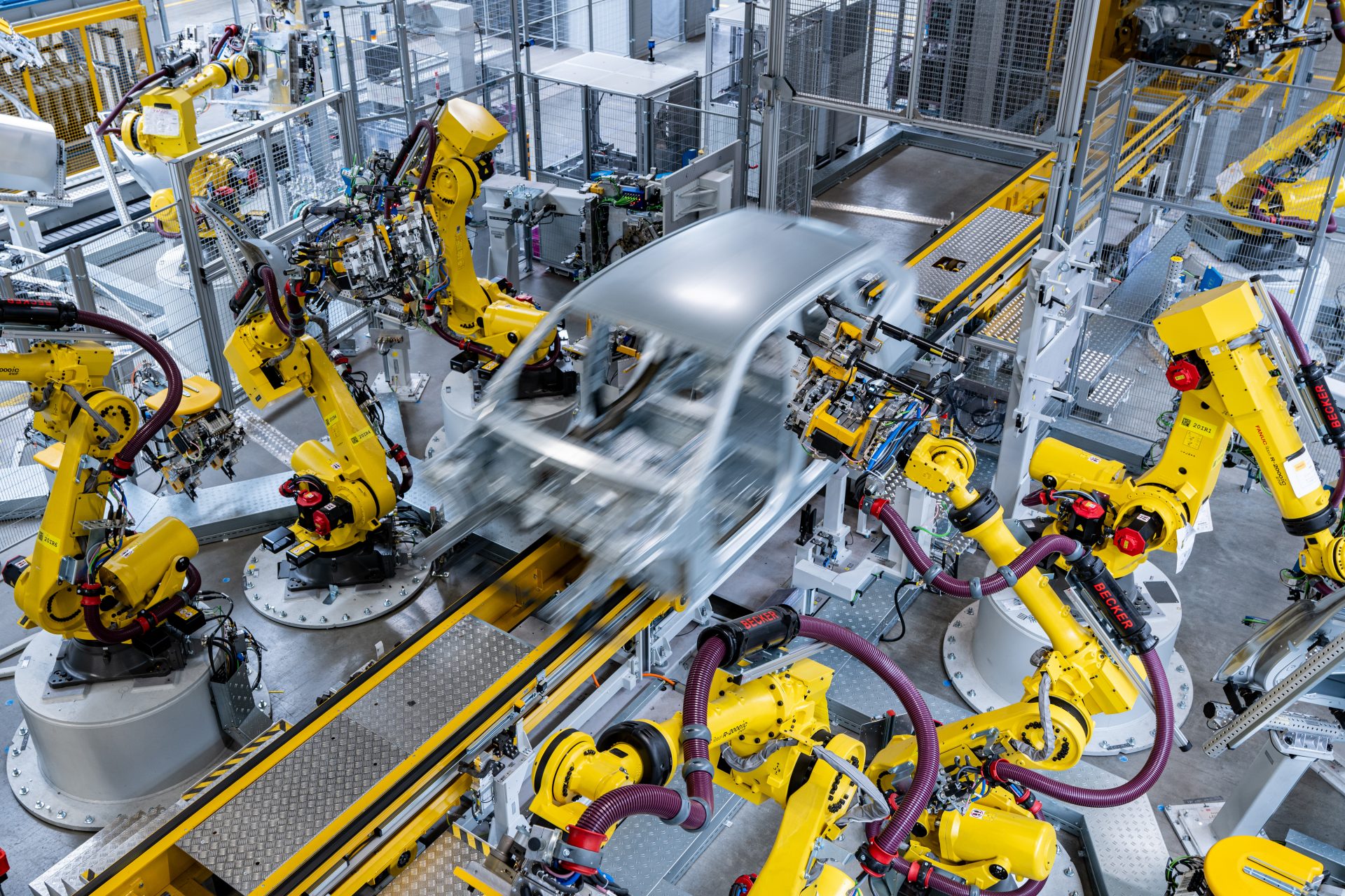 Many robot arms work on a vehicle body on the production line.