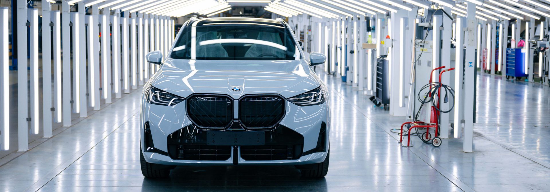  BMW X3 vehicles on the production line, showcasing assembly workers and machinery in a modern manufacturing facility.