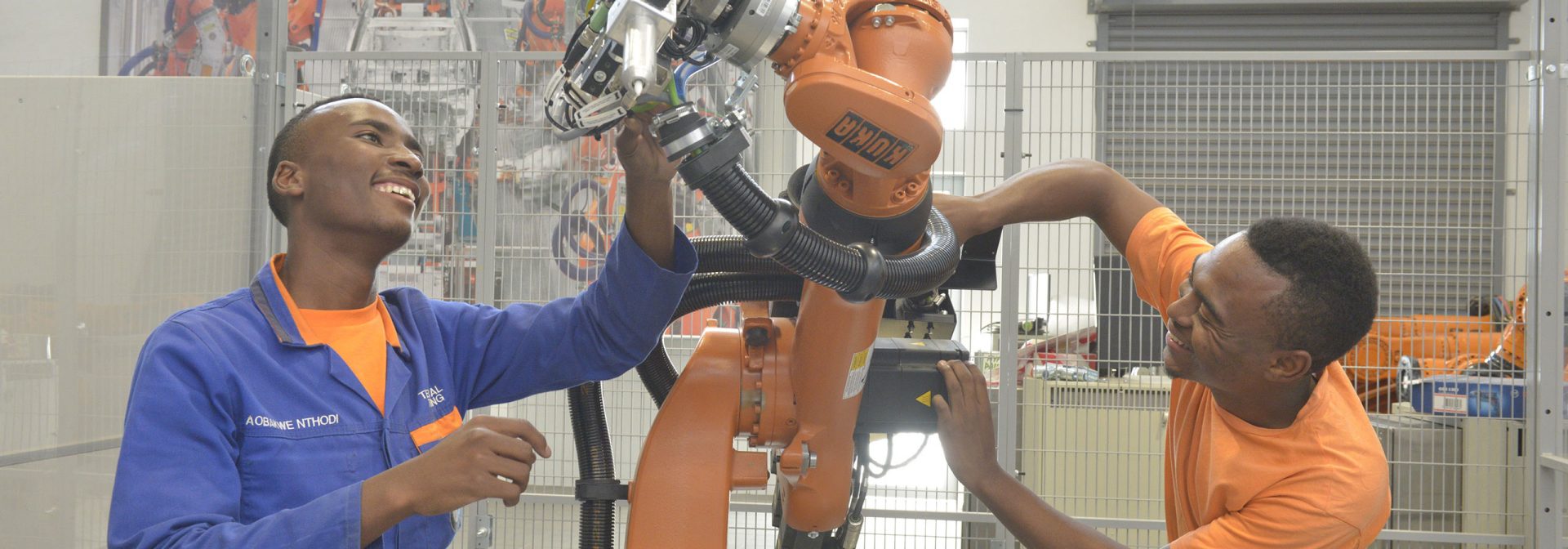  Two employees working on a machine at the BMW Training Academy in South Africa