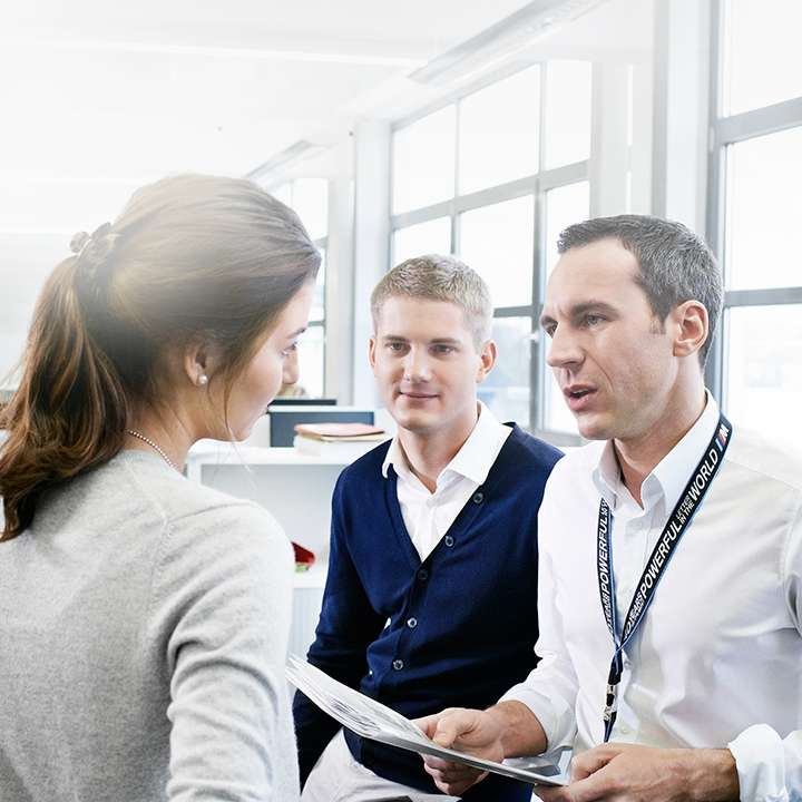 Three Professionals having a conversation in modern office environment.