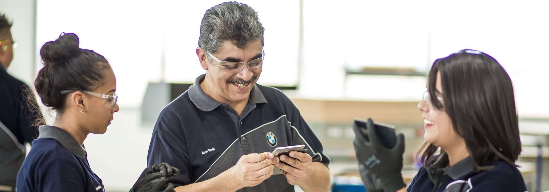 Three people working together at the anniversari of the dual program