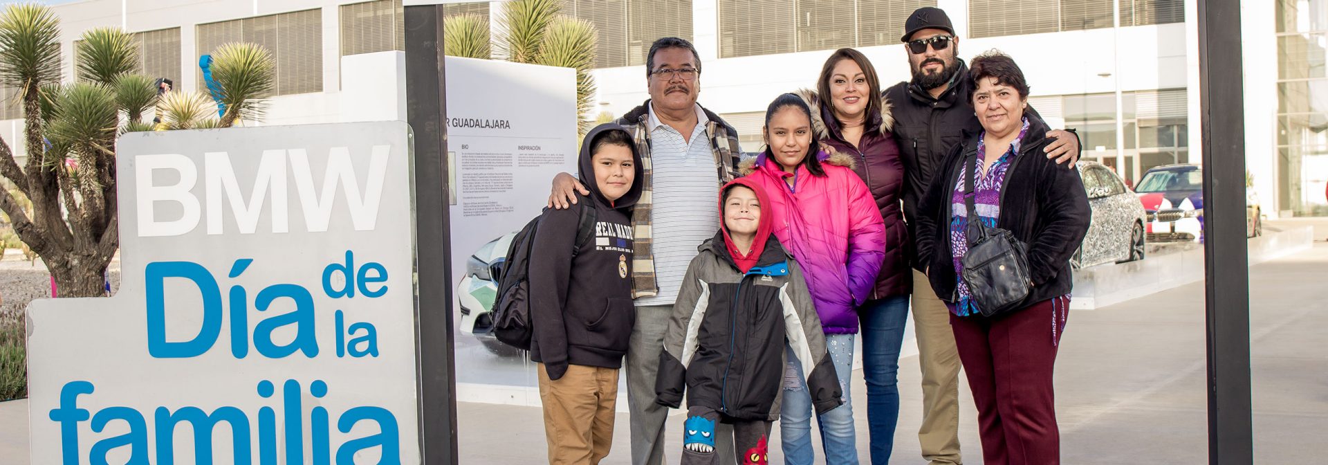 A family standing next to the BMW Día de la familia sign
