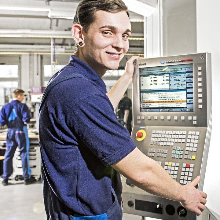 Apprentice working on a computer in the production.