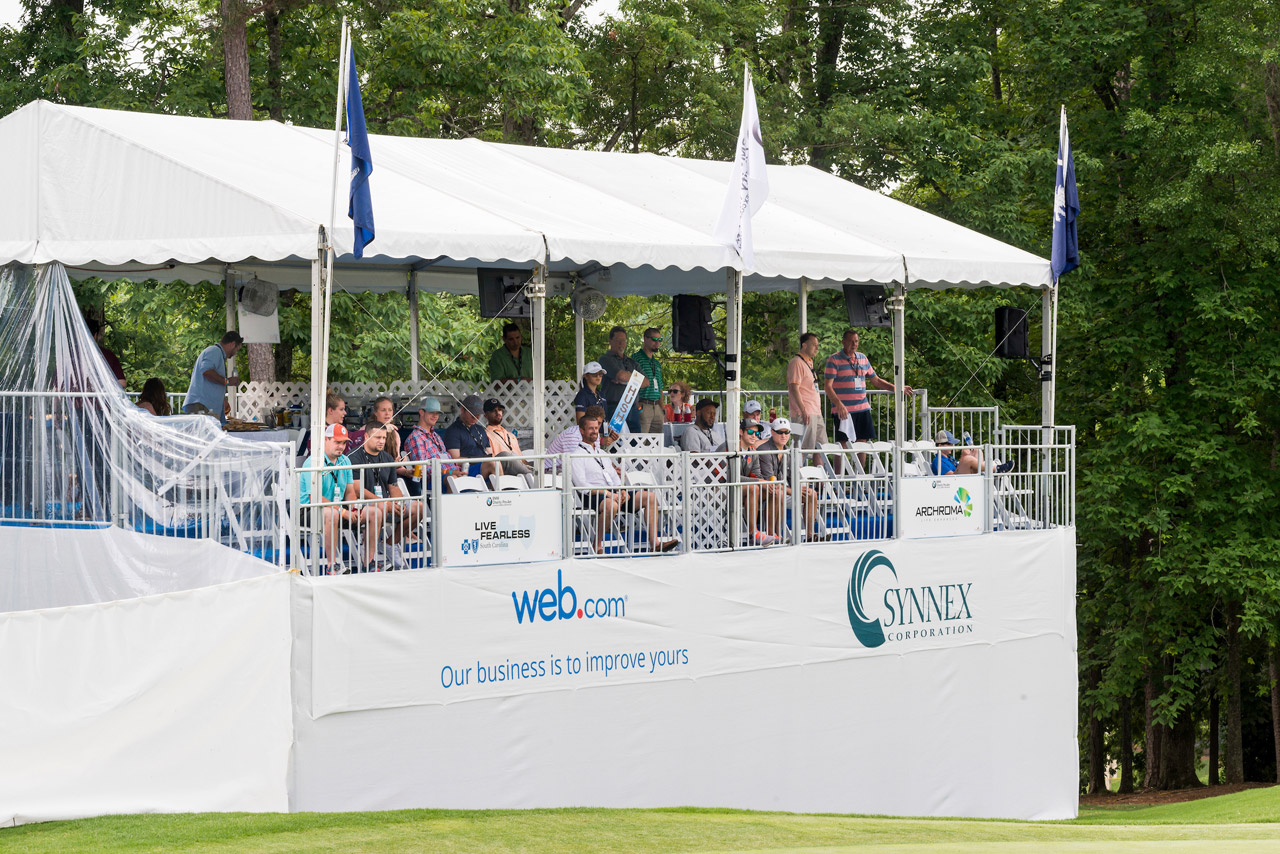 Sky box filled with spectators enjoying the 18th hole at the golf tournament. 